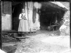 Barfuß am strohgedeckten Haus, wohl um 1900