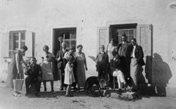 Pseudoputztrupppe mit Schäferhund vor Haus, um 1930