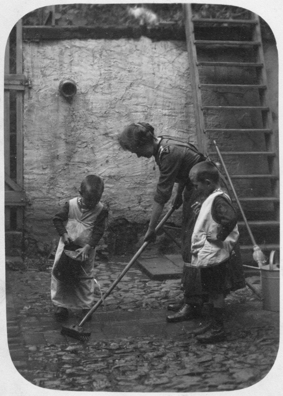Mit Mutter beim Hofschrubben, wohl 1910er