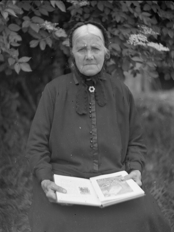 Ältere Frau mit Buch im Garten, wohl 1930er